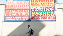 A student walking past large hoardings in Bengaluru's Marathahalli suburb. | Photo: Rajesh Subramanian
